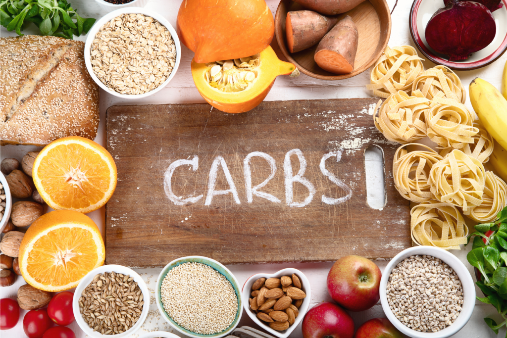 Overhead image of various types of carbs including bread, pasta, and fruit