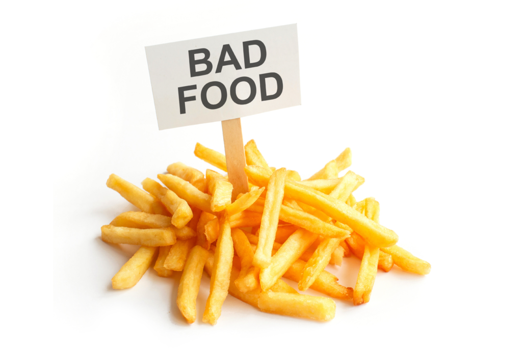 Image of french fries with a sign in them that says "bad food".
