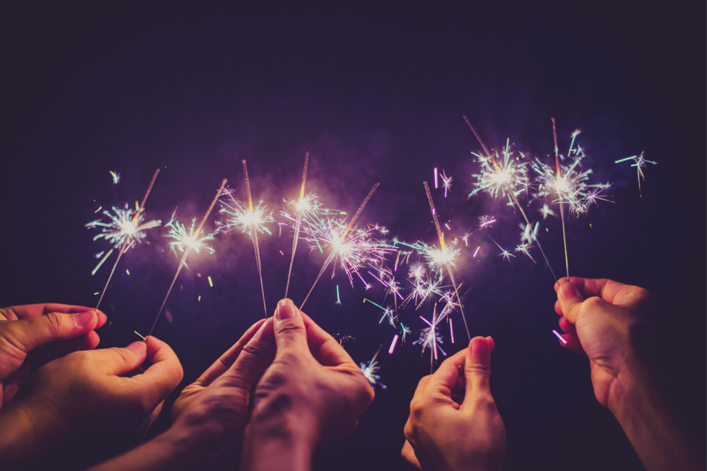 hands holding up sparklers for new years party or for the holidays
