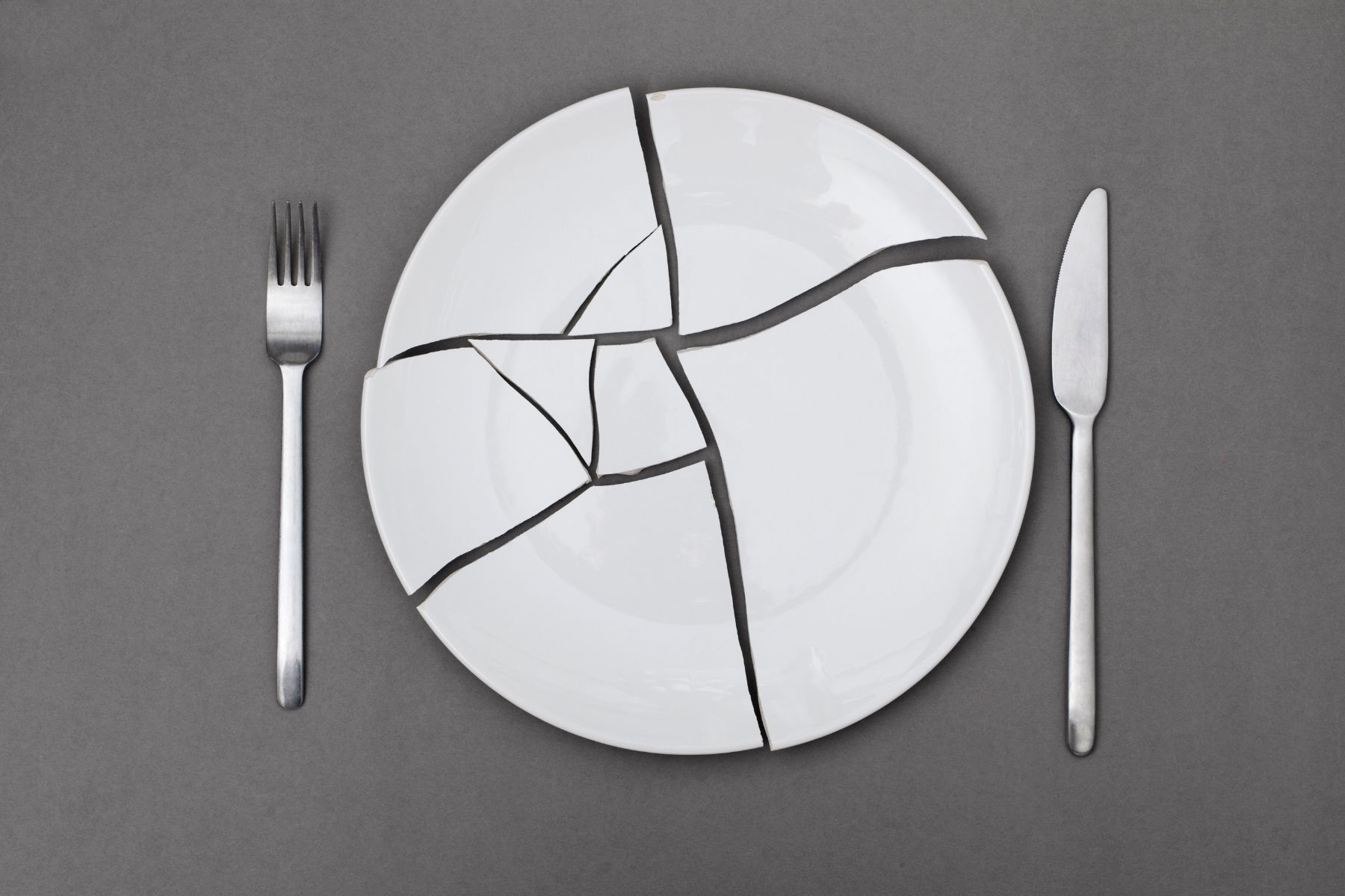 broken plate between a fork and a knife