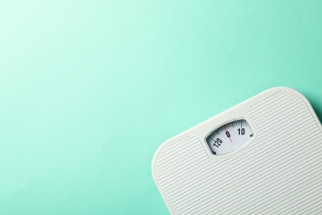 White body weight scale in the right hand corner of the image on a turquoise blue background.