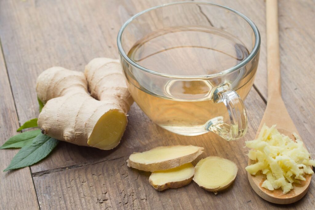 Image of ginger tea and ginger root on a wooden surface, a digestion aid. 