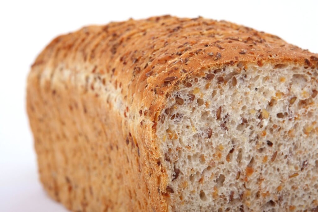 Image of a loaf of whole grain bread on white background. 