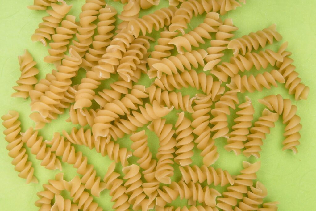 Curly pasta noodles over a green background